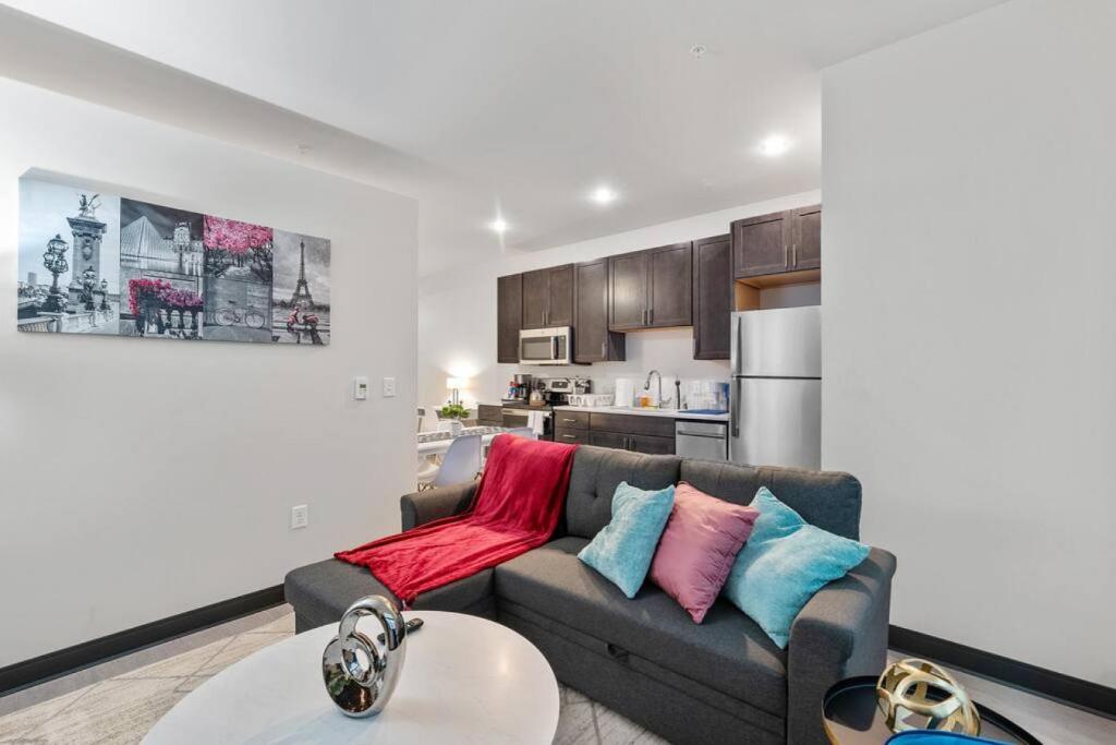 a living room with a gray couch with colorful pillows at Journal Commons 332 Lavish 1BR at Historic Journal Sentinel 65 TV in Milwaukee