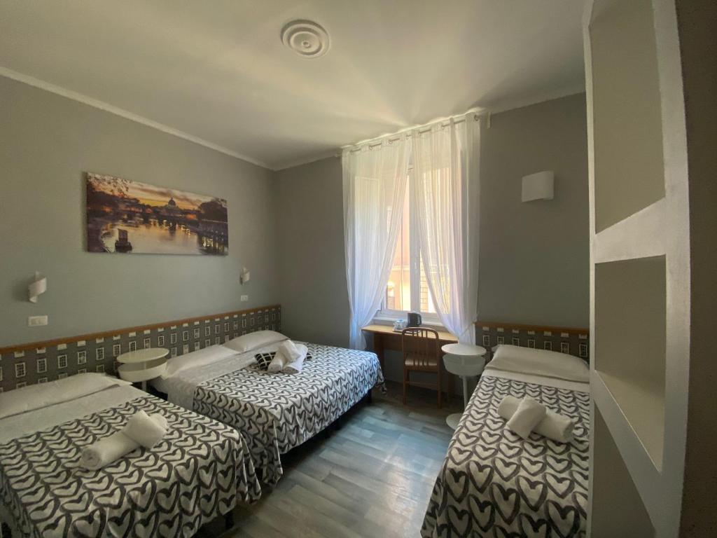 a hotel room with two beds and a window at GUEST HOUSE FIDARDO in Rome