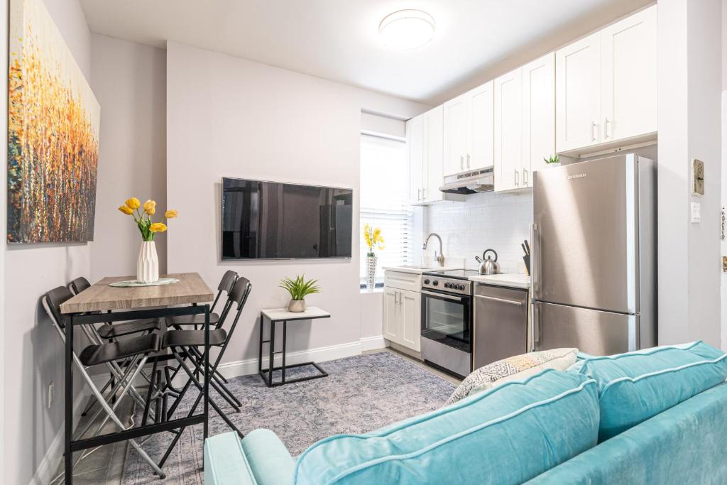 a living room with a blue couch and a kitchen at 3BR Chelsea in NYC in New York