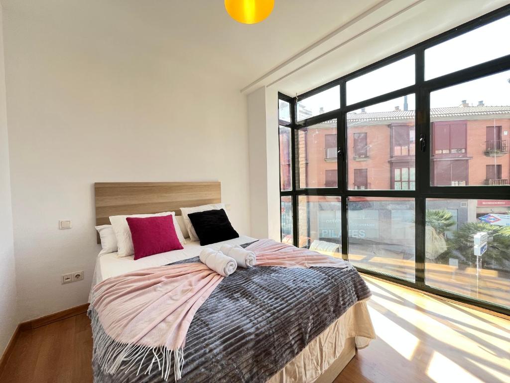 a bedroom with a bed and a large window at Luminoso Madrid Javalambre in Madrid