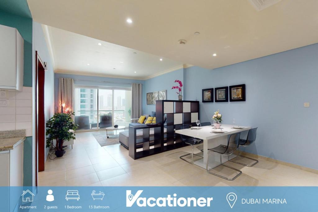 Una cocina y una sala de estar con una mesa y un sofá. en Marina Heights - Unique One Bedroom, en Dubái