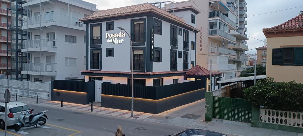 a building with a sign on it on a city street at APARTAMENTOS Posada Del Mar in Los Mártires