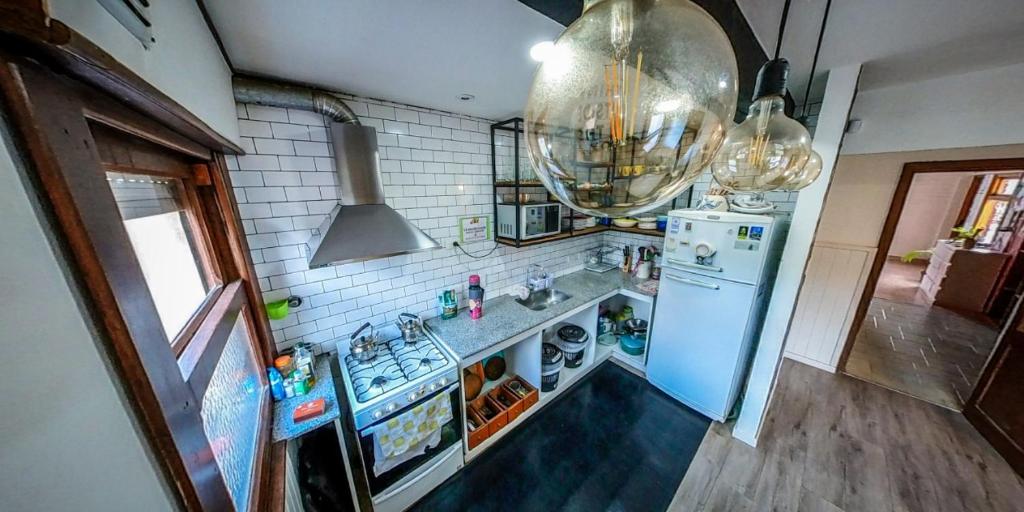cocina con refrigerador azul y fregadero en Pintó Casa Hostel en Esquel