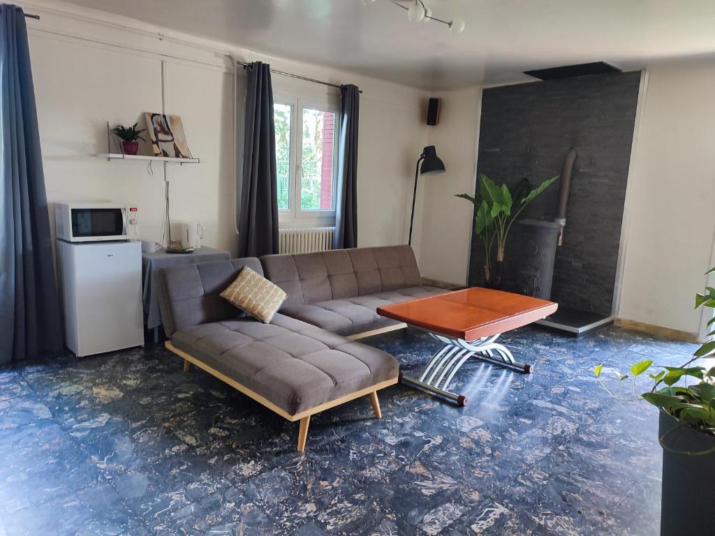 ein Wohnzimmer mit einem Sofa und einem Tisch in der Unterkunft Suite privée in Montélimar