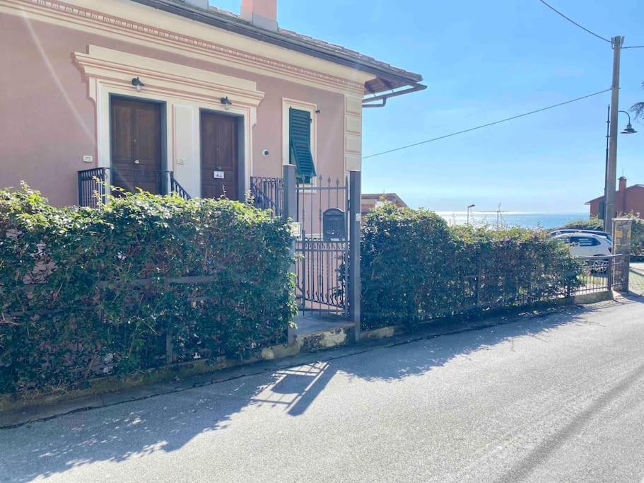 a house with a gate and bushes next to a street at Bilocale grazioso montefiorito in Recco