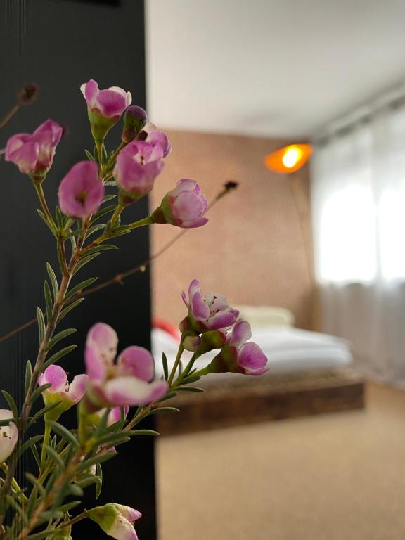 un jarrón con flores púrpuras en una habitación en PrivArtZimmer 'Ausfahrt freihalten', en Husum