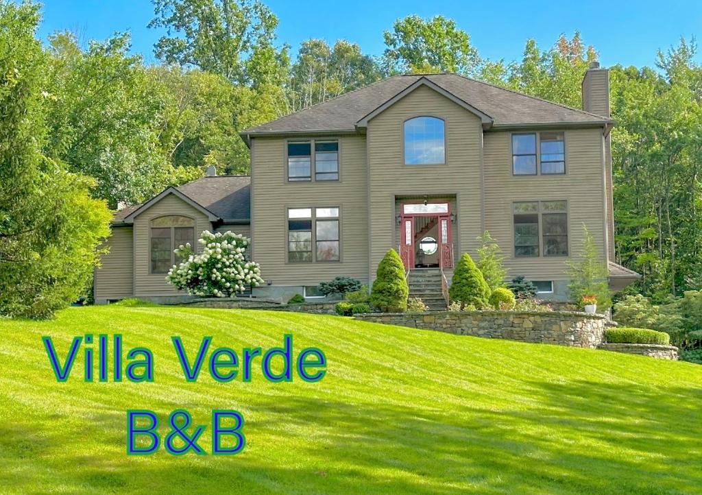 a house with a green lawn with the words villa yard bc at Villa Verde B&B, Greenwood Lake, NY in Monroe