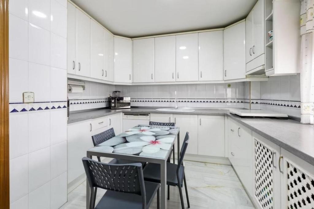 een grote witte keuken met een tafel en stoelen bij Ludesa - Modern Accommodation in Palma de Mallorca
