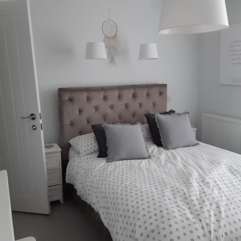 a bedroom with a bed with pillows on it at Hideaway Cottage - Private ensuite room - 4 minutes to the sea! in Sandgate