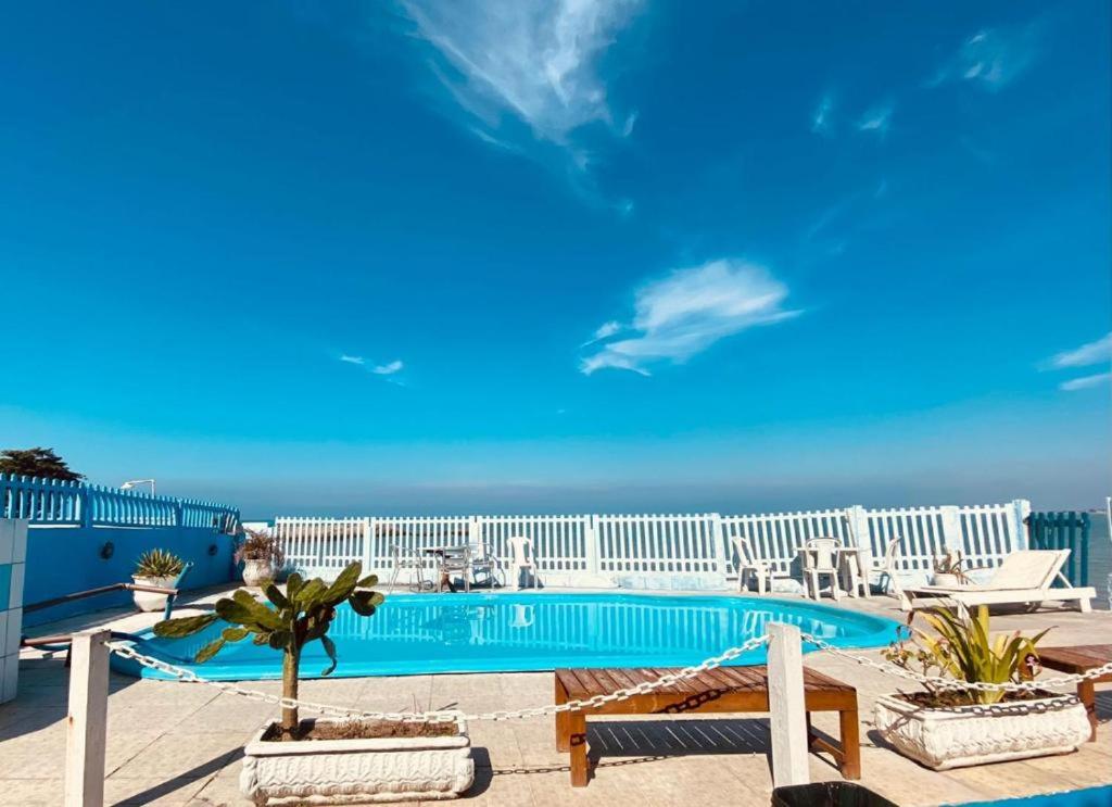 a swimming pool with a view of the ocean at Pousada das Tartarugas in Rio das Ostras