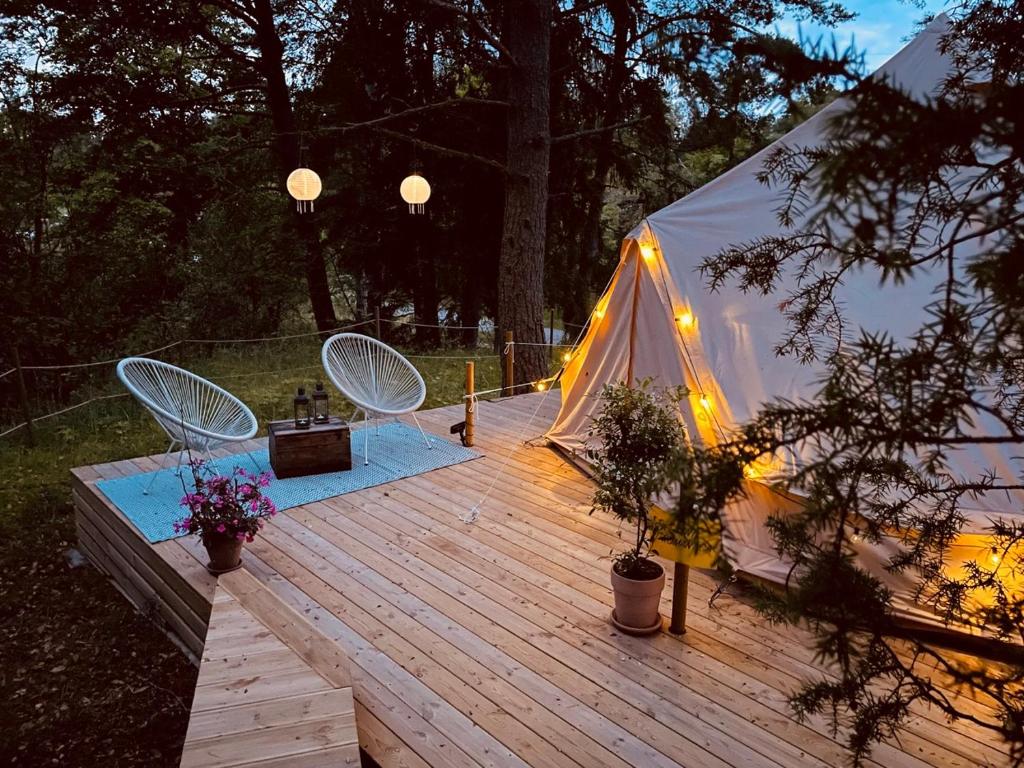 Tienda en una terraza de madera con mesa y sillas en tent romantica a b&b in a luxury glamping style, en Mariefred