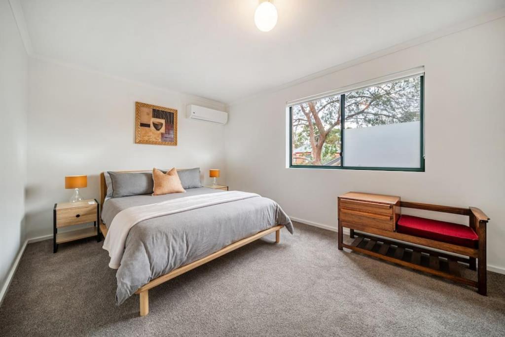 a bedroom with a bed and a window at Poppy on the Lane - WiFi CBD in Thebarton