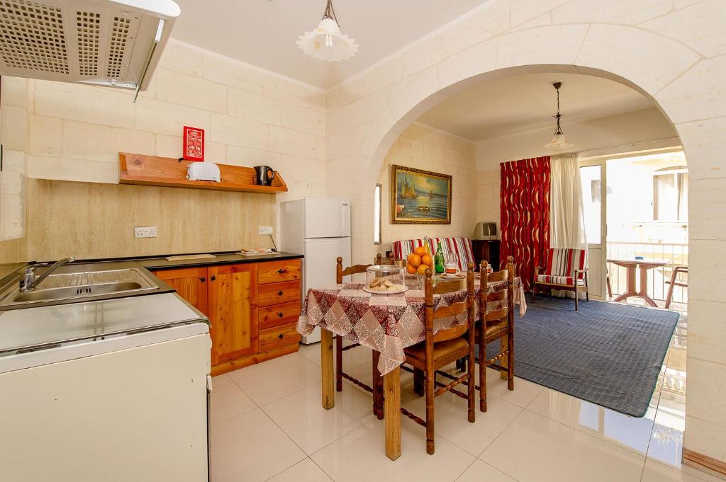 a kitchen and dining room with a table and chairs at Lantern Guest House in Marsalforn