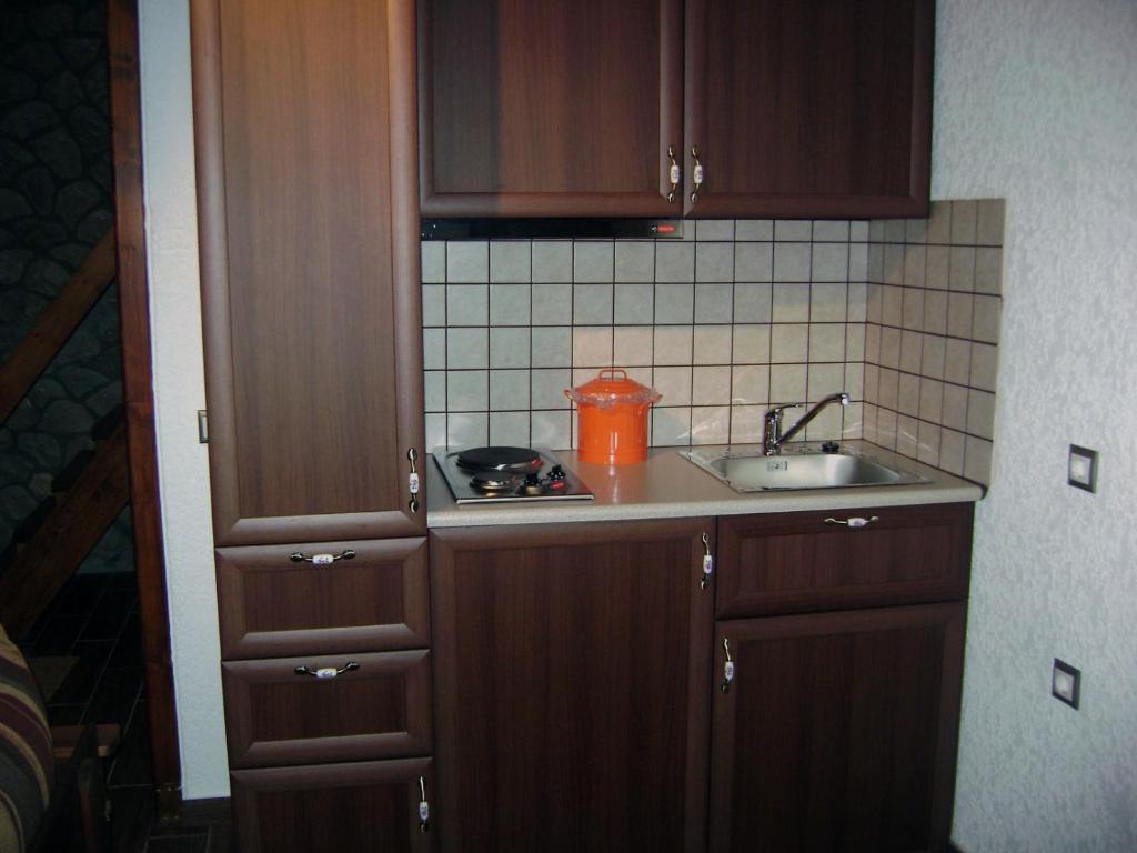 uma pequena cozinha com armários de madeira e um lavatório em PS Apartment Polydrosos - PS Rental em Polydrosos