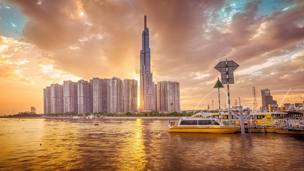 a city with buildings and boats in the water at DongDong Luxury Apartment in Vinhomes Central Park in Ho Chi Minh City