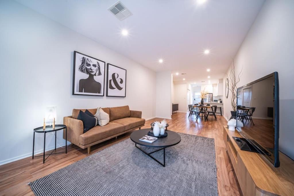 a living room with a couch and a table at Black Oak at Brompton – Contemporary Parkside Stay in Bowden