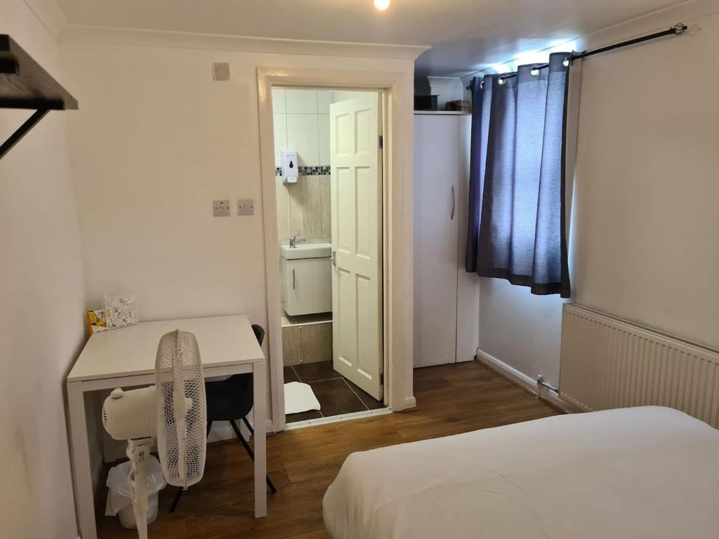 a bedroom with a bed and a desk and a mirror at Close To Tower Bridge Central London - 4 Bedroom House - 3 Bathrooms - Free Parking 3 Cars - Sleep 9 in London
