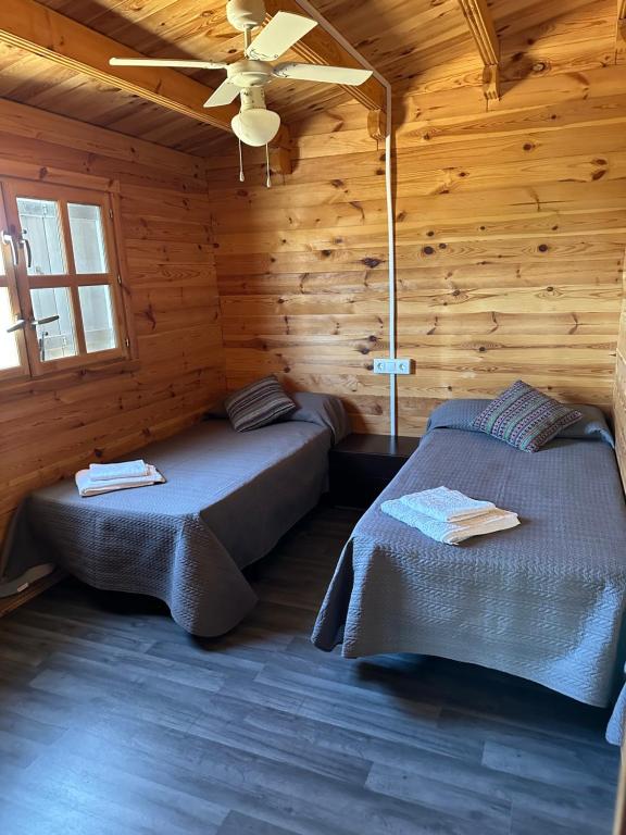 a bedroom with two beds in a wooden cabin at Kalma experiencias turísticas in Cádiz