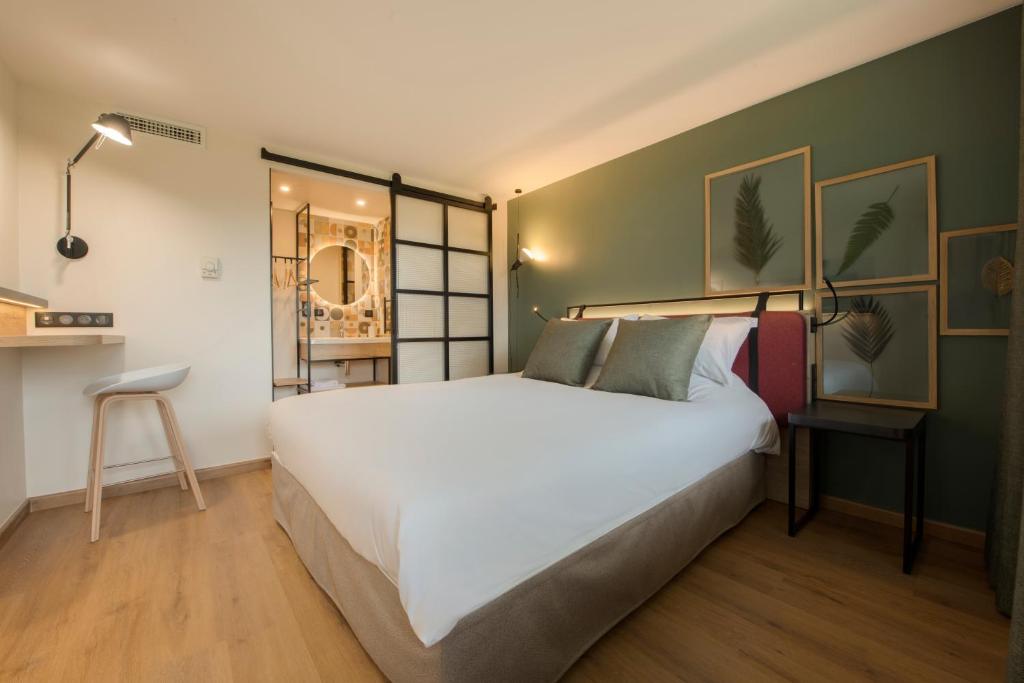 1 dormitorio con 1 cama blanca grande y paredes verdes en Campanile Metz - Jouy-Aux-Arches en Jouy-aux-Arches