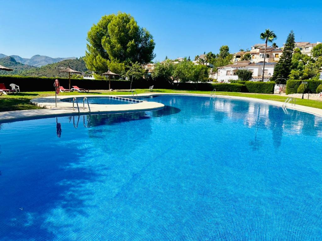 a large swimming pool with blue water at Stunning mountain views! Private Villa with fabulous communal pool! in Murla