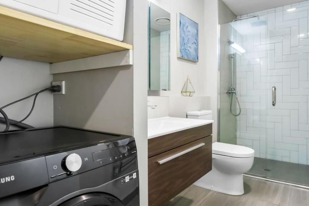 a bathroom with a washer and dryer in it at Quality in Heart of Albany - Wi-Fi - Free Parking in Auckland