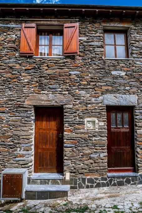 a stone building with two doors and windows at Casa da Ernesta in Mondim de Basto