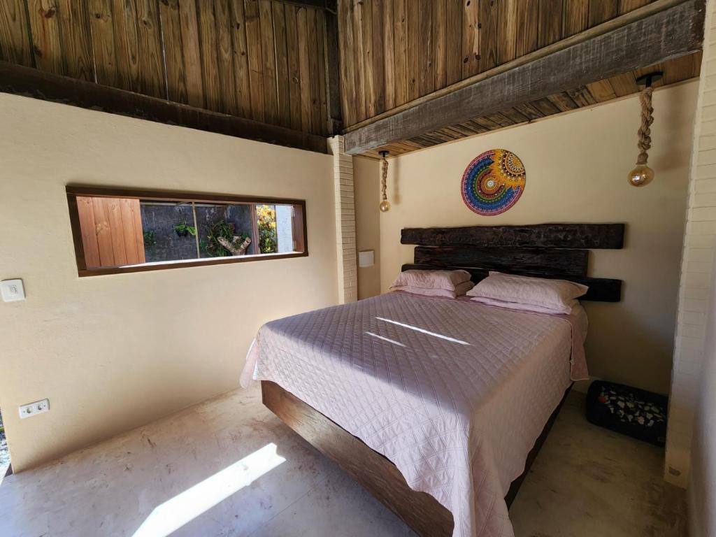 een slaapkamer met een bed in een kamer met een raam bij Loft romântico pé na areia in Itapoa
