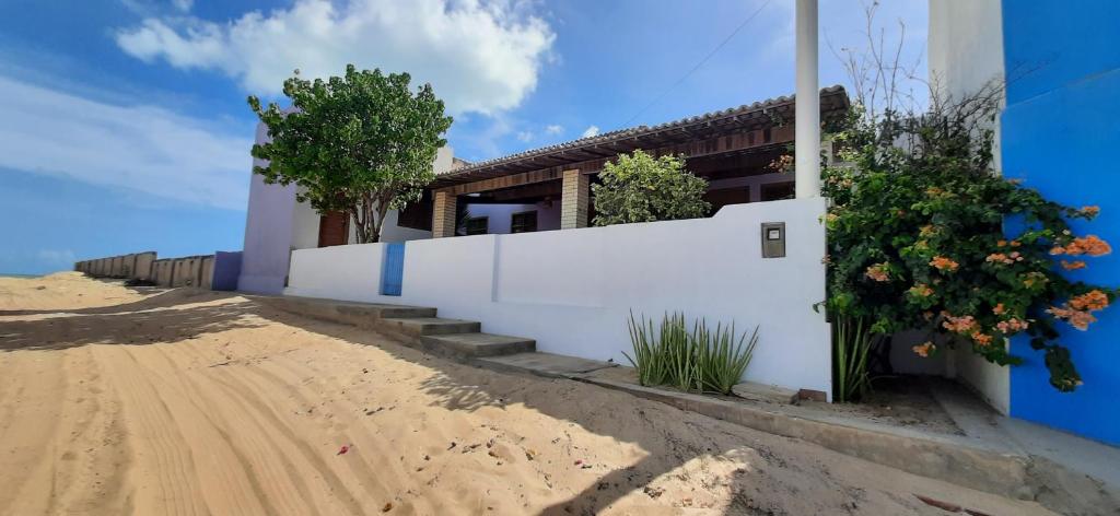 ein Haus am Strand mit einem weißen Zaun in der Unterkunft Casa Grande in Galinhos