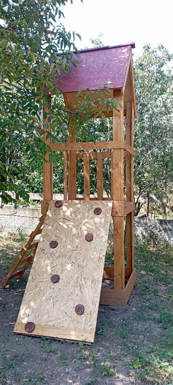 a small wooden play structure with a slide at Hooni_guesthouse in Odzun