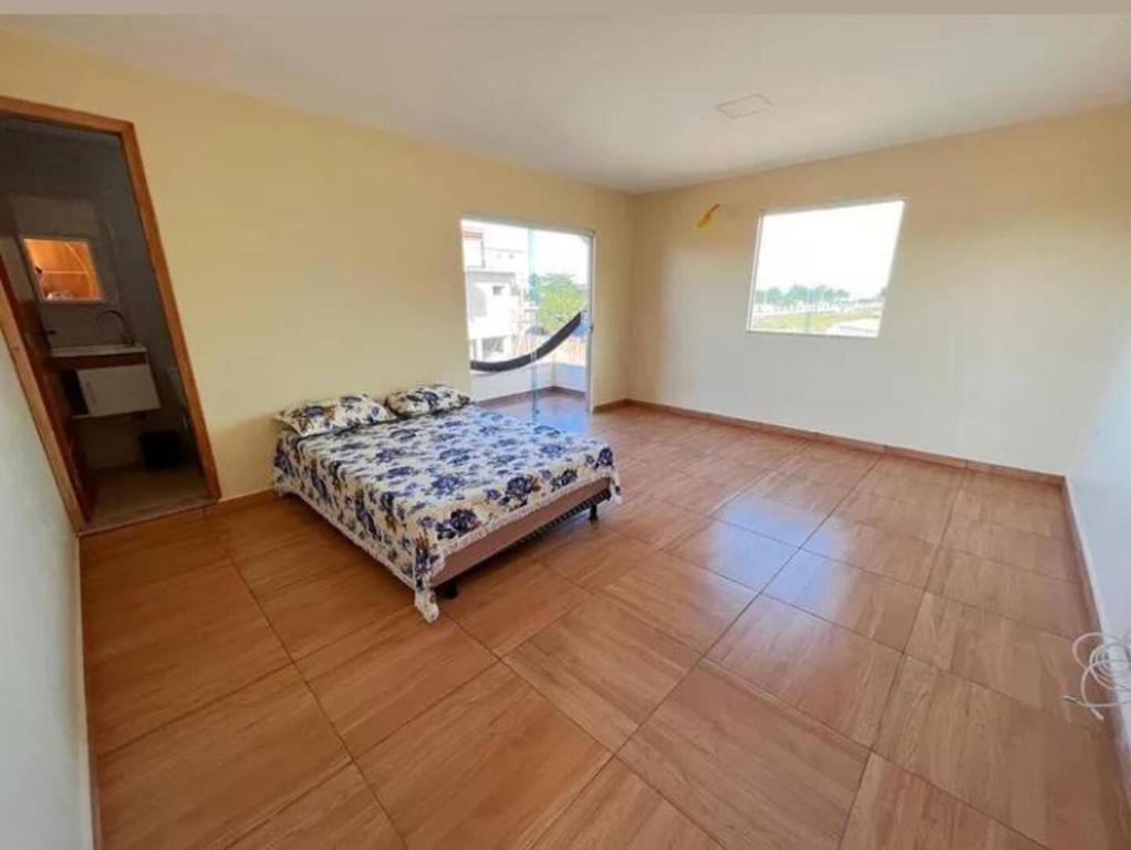 um quarto com uma cama e piso em madeira em Casa de Praia Pontal em Ilhéus