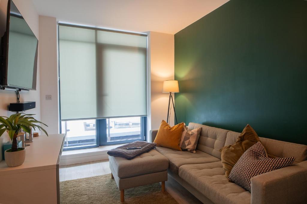 uma sala de estar com um sofá e uma grande janela em Modern and Spacious Apartment in Salford Quays em Manchester