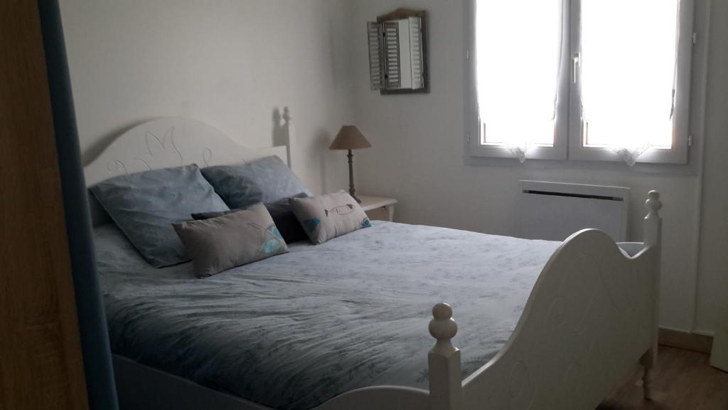 Pont-Croix的住宿－Le Chat Bleu，一间卧室配有白色床和蓝色枕头