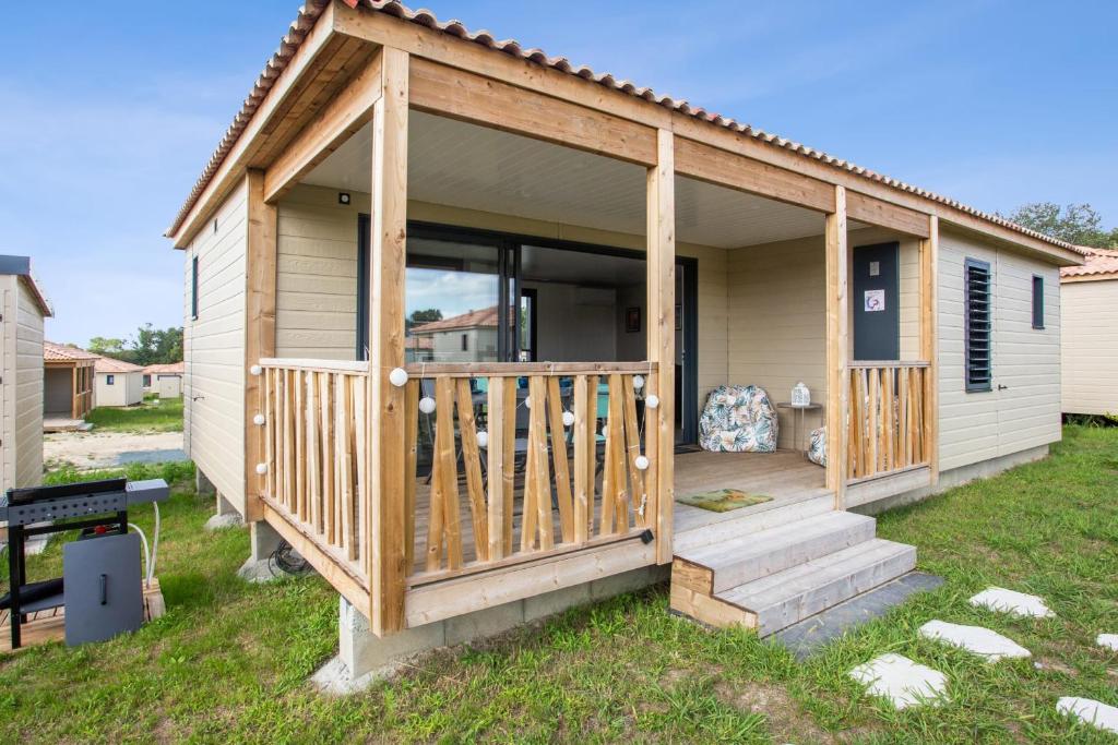 une cabine avec une terrasse couverte et une terrasse dans l'établissement D&D Cottage - Welkeys, à Saubrigues