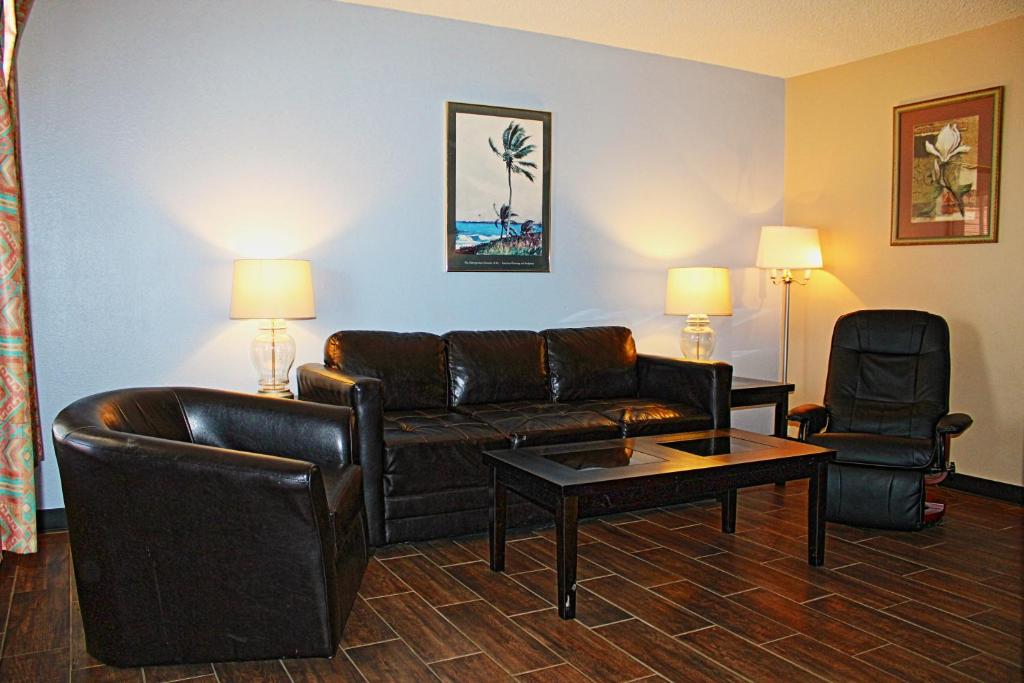 a living room with a couch and a table and chairs at Victoria Palms Inn and Suites in Donna