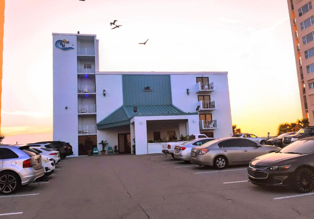 a parking lot with cars parked in front of a building at Beachside Hotel - Daytona Beach - NO POOL in Daytona Beach