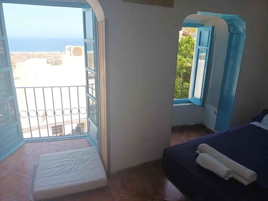 a room with a bed and a large window at Pension El Torreon in Mojácar