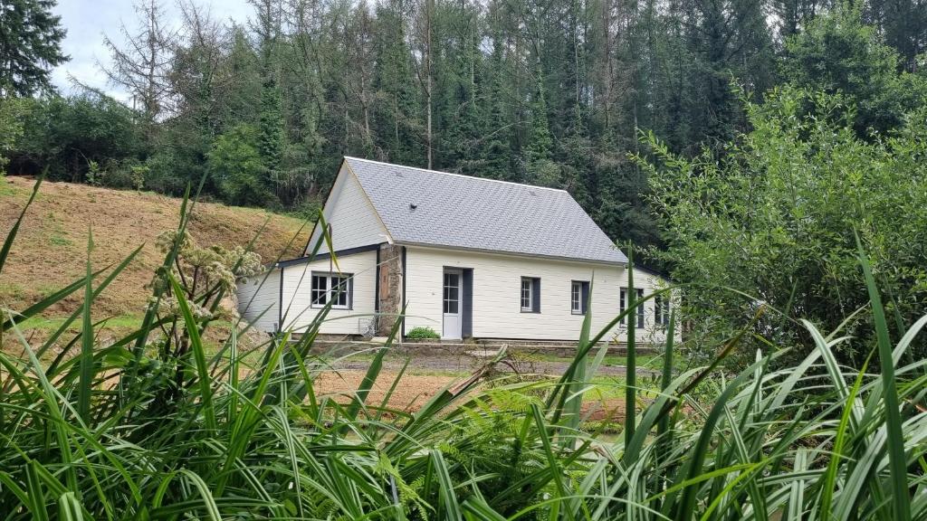 ein kleines weißes Haus mitten auf einem Feld in der Unterkunft Maison au cœur des Bois in Saint-Martin-de-Sallen