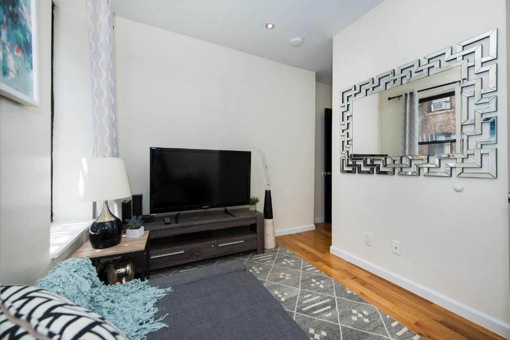 a living room with a flat screen tv on a wall at 3BR in Amsterdam Ave! in New York