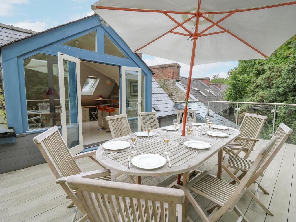 a table and chairs with an umbrella on a deck at Tan y Craig in Haverfordwest