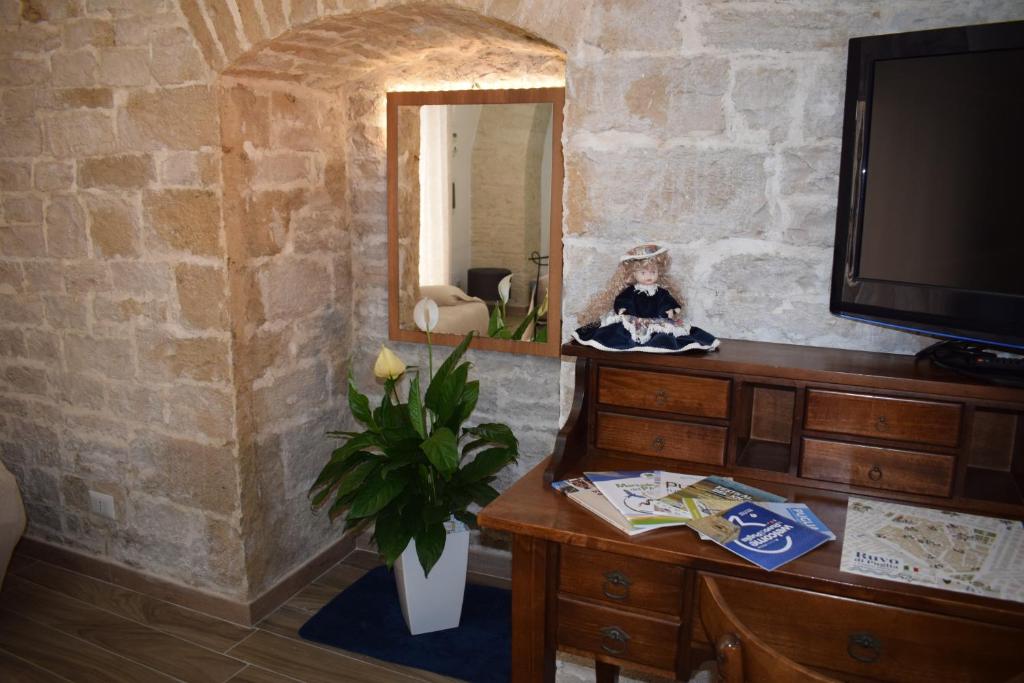Zimmer mit einem Spiegel, einer Kommode und einem TV in der Unterkunft FA.RÒ. DIMORA in Ruvo di Puglia