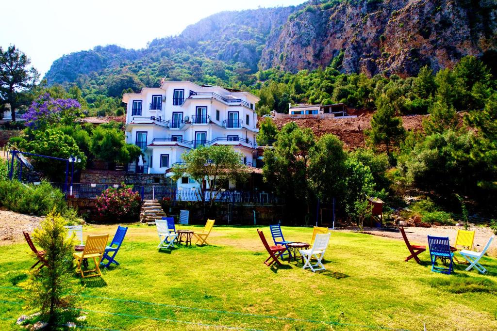 a group of chairs and tables in a yard with a house at Lavanta Butik Otel Turunc in Turunç