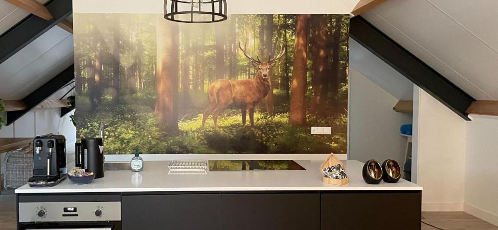 een schilderij van een hert in een bos bij Boerderij appartement De Casterie in Bornerbroek
