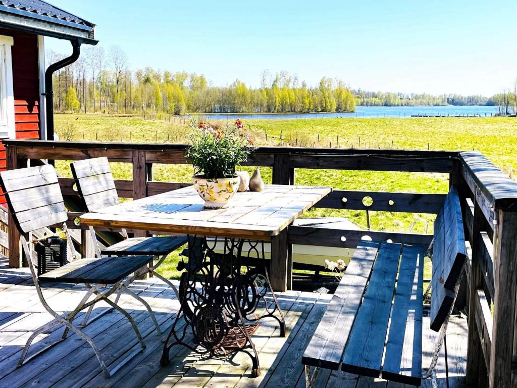 una mesa de madera y sillas en una terraza con vistas al lago en Holiday home ALVESTA II, en Alvesta