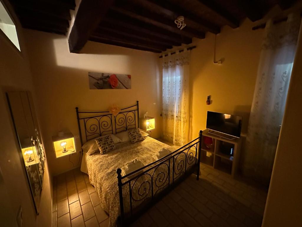 1 dormitorio con cama, TV y luces en Incanto, en Parma