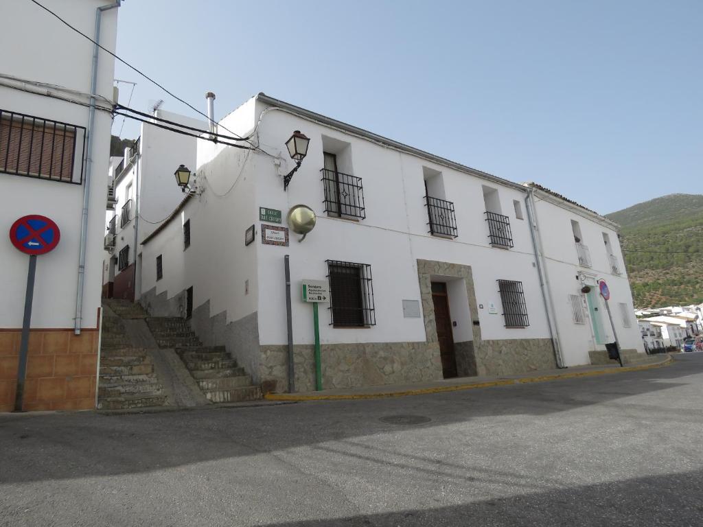 a white building on a city street with a street sign at CASA ALEGRIA in Algodonales