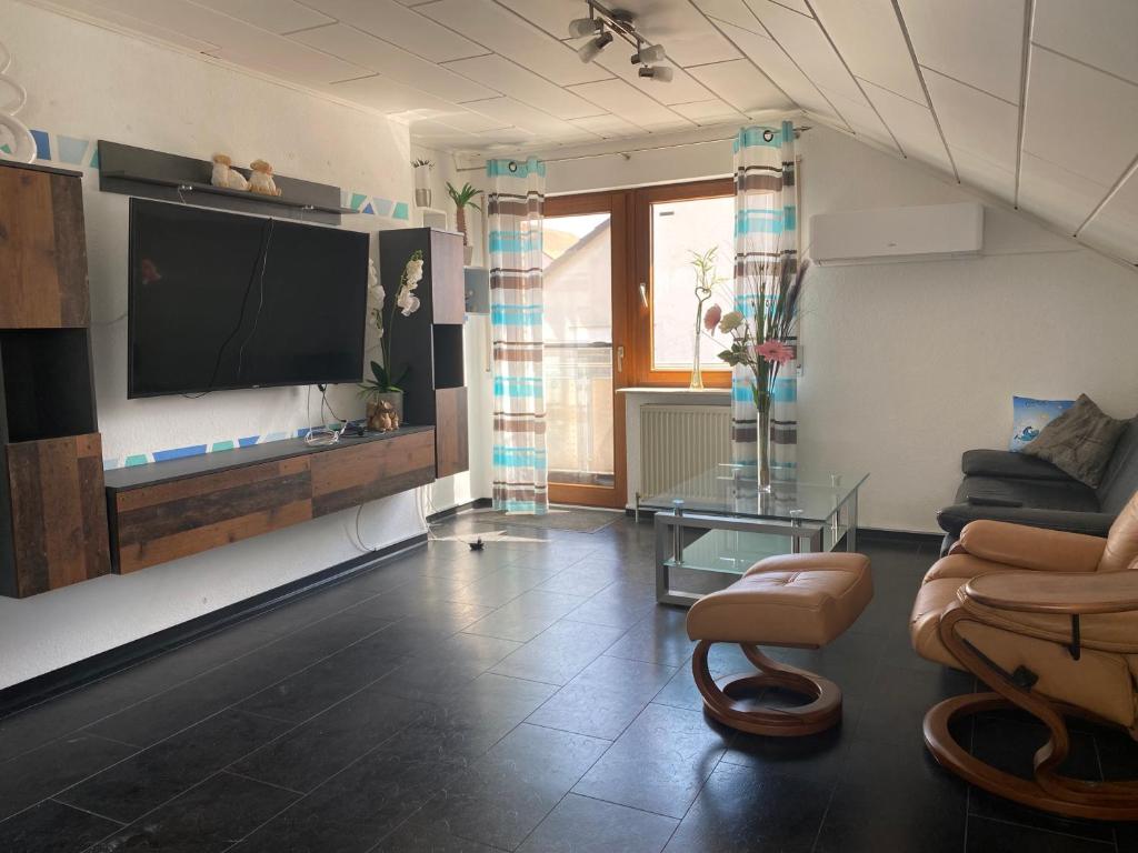 sala de estar con TV de pantalla plana en la pared en Moderne Ferienwohnung Neckarschleife mit Klimaanlage en Kirchheim am Neckar