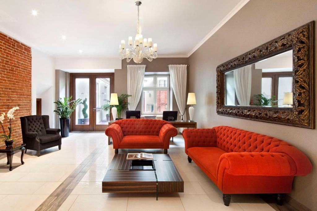 a living room with red furniture and a mirror at Metropolitan Boutique Hotel in Kraków