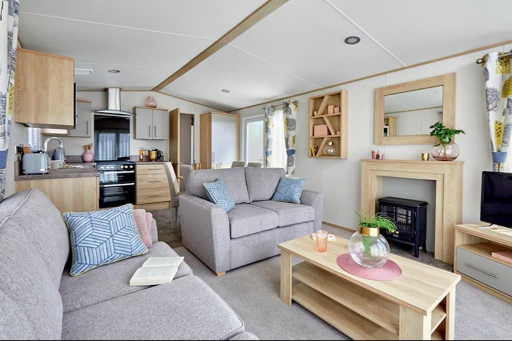 a living room with a couch and a table at Platinum Holiday Home by the Sea in Whitstable