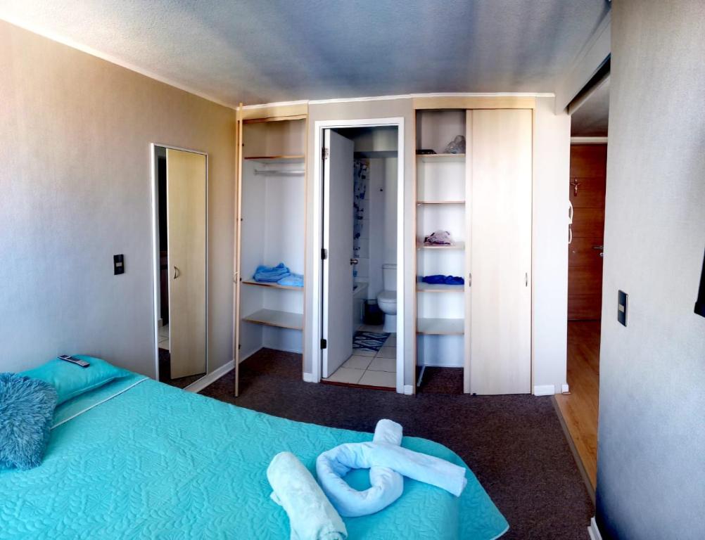 um quarto com uma cama azul e um par de toalhas em Lindo Departamento Amoblado (Santiago) em Santiago