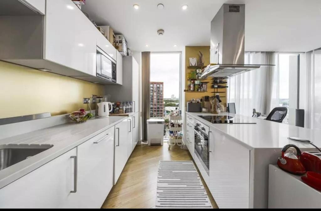 a kitchen with white appliances and a large window at Ontario Point Flat only double bedroom in London